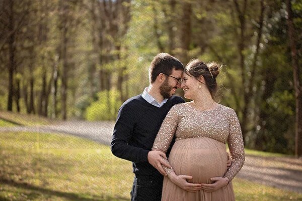 Couple heureux en extérieur lors d'une séance photo de grossesse en nature