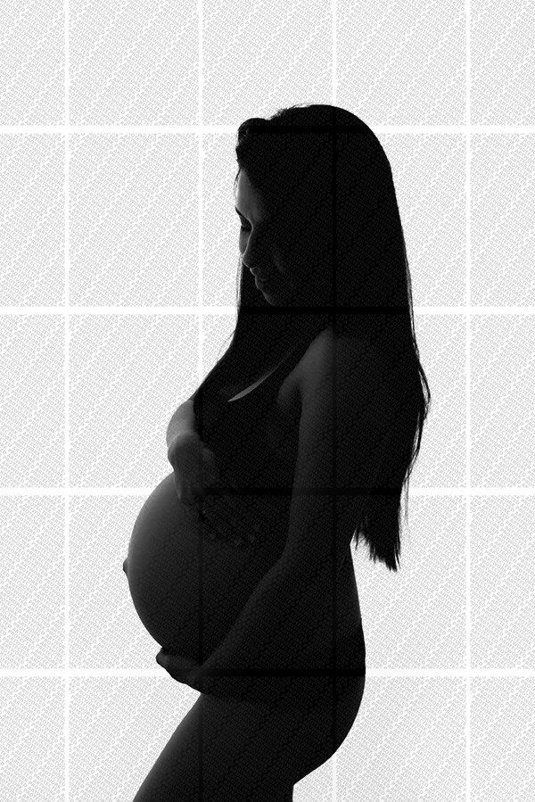 Silhouette en contre-jour d'une femme enceinte en profil, main posée sur son ventre arrondi